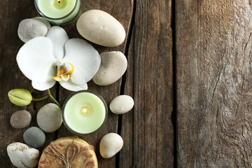 Fototapeta na wymiar Still life with beautiful blooming orchid flower, spa treatment and pebbles, on wooden background