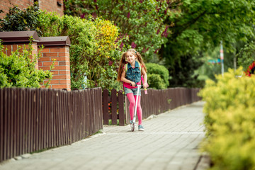 girl goes to school on a scooter