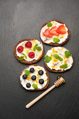 Bruschetta with fresh berries, goat cheese, honey and chia seeds. top view