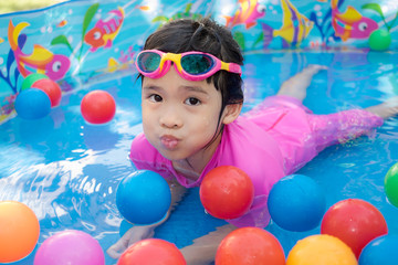 Obraz na płótnie Canvas Baby girl playing in kiddie pool