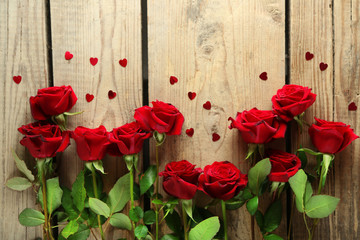 Fototapeta na wymiar Beautiful red roses on old wooden table