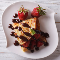 crepes with strawberries and chocolate close-up top view
