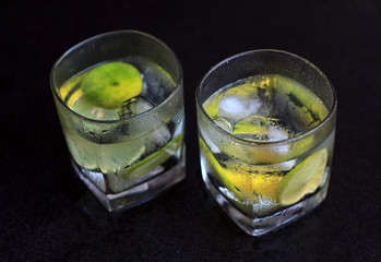 Lemonade served on a dark marble bar with a lime