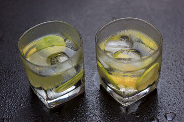 Lemonade served on a dark marble bar with a lime