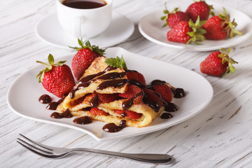 crepes with strawberries and coffee close-up. Horizontal
