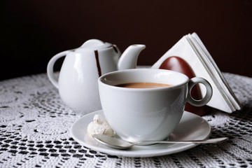 Hot chocolate in mug, on table, on dark background