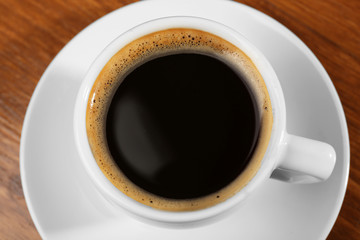 Cup of fresh coffee on wooden table, closeup