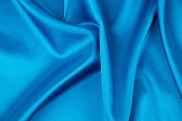 Folds of deep blue silk cloth texture.