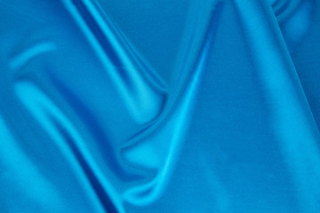 Folds of blue silk cloth texture.