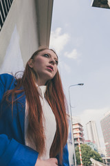 Obraz premium Beautiful redhead girl posing in an urban context