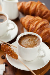 Fresh croissants  and cup of coffee on a table