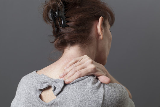 mature woman suffering from backache and neck tensions