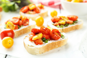 Tasty fresh bruschetta with tomatoes on white wooden background