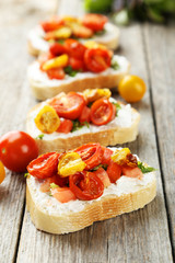 Tasty fresh bruschetta with tomatoes on grey wooden background