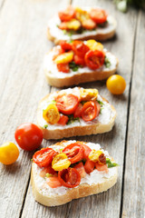 Tasty fresh bruschetta with tomatoes on grey wooden background