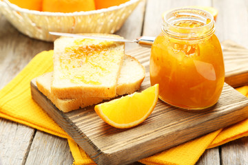 Bread and orange jam on grey wooden background