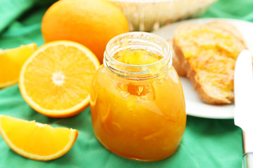 Bread with orange jam on green background