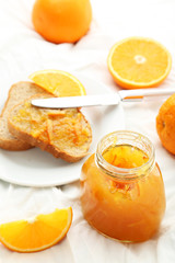 Bread with orange jam on white background