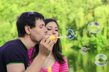 couple having fun with soap bubbles in the park