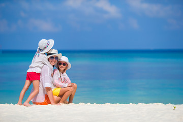 Little girls and mother on tropical white beach 