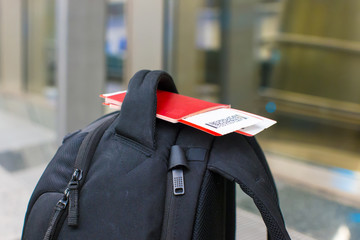 Closeup passports and boarding pass on backpack at airport