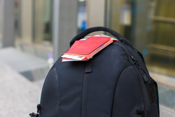 Closeup passports and boarding pass on backpack at airport