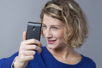 Adorable female teenager winking for self-portrait on cell phone