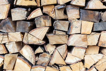Background of dry chopped firewood logs in a pile