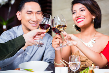 Asian friends dining in fancy restaurant