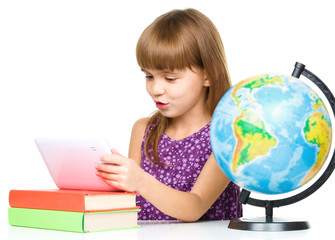 Young girl is using tablet while studying