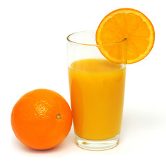 Orange juice in a glass and oranges