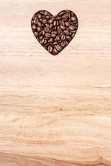 Heart shaped coffee beans on wooden board