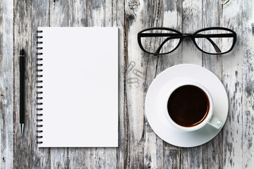 Obraz na płótnie Canvas Blank diary and coffee cup on a vintage wooden table