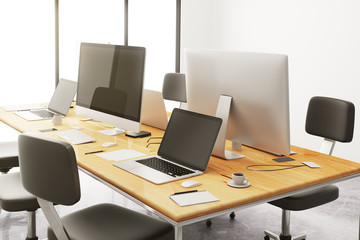 wooden conference table with office accessories and computers