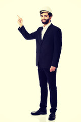 Engineer in protective helmet pointing up.