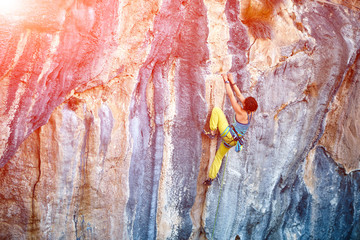 Rock climber climbing up a cliff