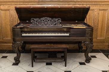 Fototapeta na wymiar closeup view of old beautiful gorgeous vintage piano standing against wooden background