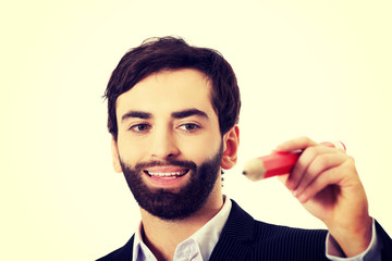 Intelligent man writing with big pencil.