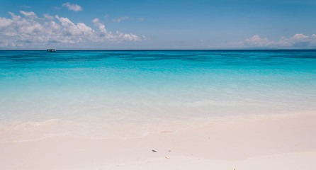 Fototapeta na wymiar blue sky with sea and beach - soft focus with film filter