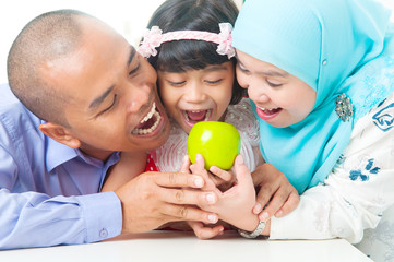 Malay family eating apple
