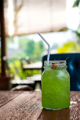 Green kiwi iced beverage on wooden table