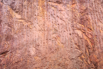 Texture of mountain showing red soil and rock