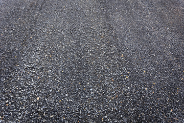 Texture black pebble stone on the road in Thailand