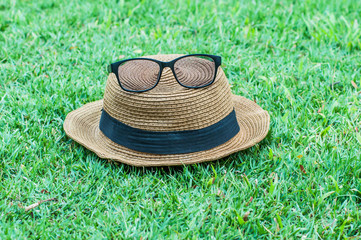 Hats glasses on grass at park.