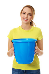 Young woman holding blue bucket.