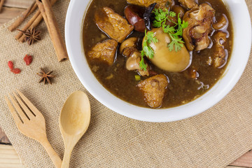 Pork and egg stewed in the gravy on wooden table