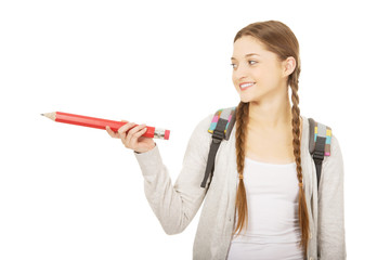 Schoolgirl pointing aside with pencil.