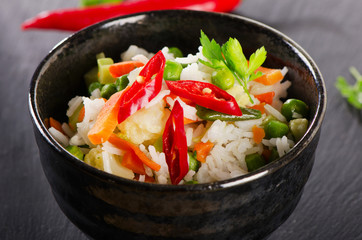 Rice and  vegetables on a black table.