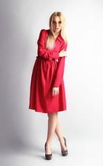 Expressive young model in red dress on gray background
