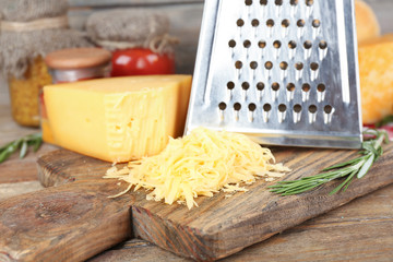 Grated cheese on wooden cutting board, closeup